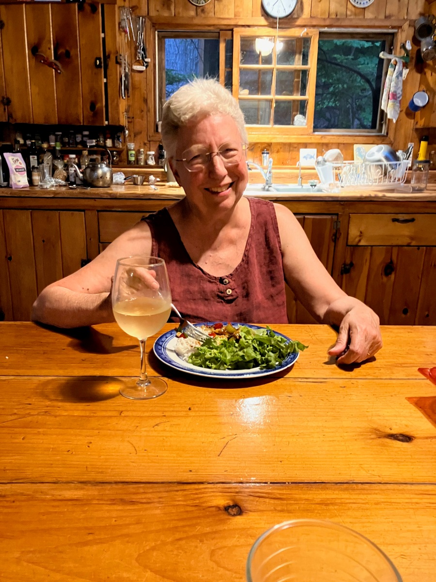 Kate smiling over delicious dinner and glass of Chardonnay